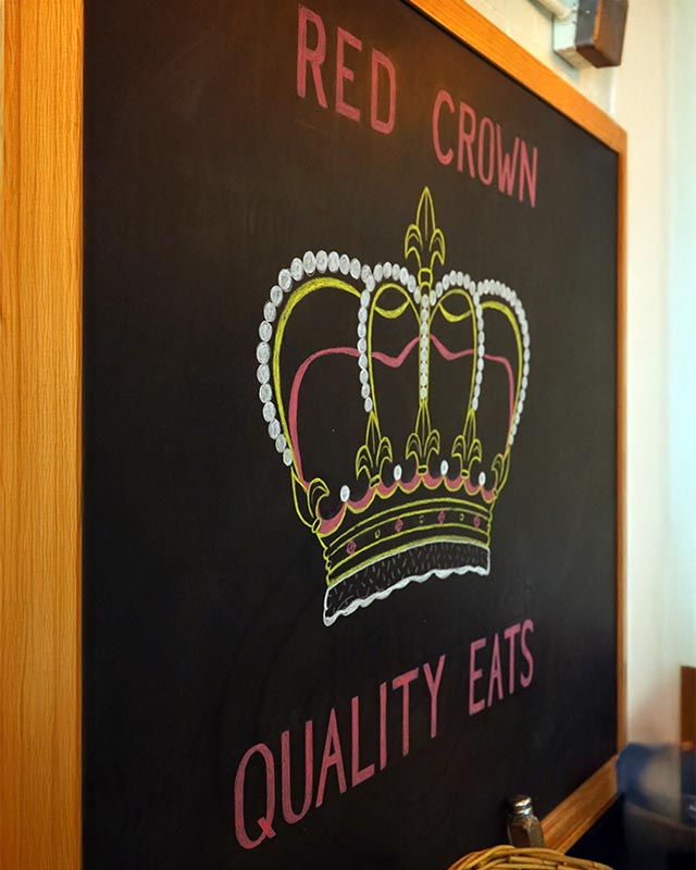 Chalkboard crown logo inside Red Crown Quality Eats, a Grosse Pointe Park sports bar serving burgers, sandwiches, and salads