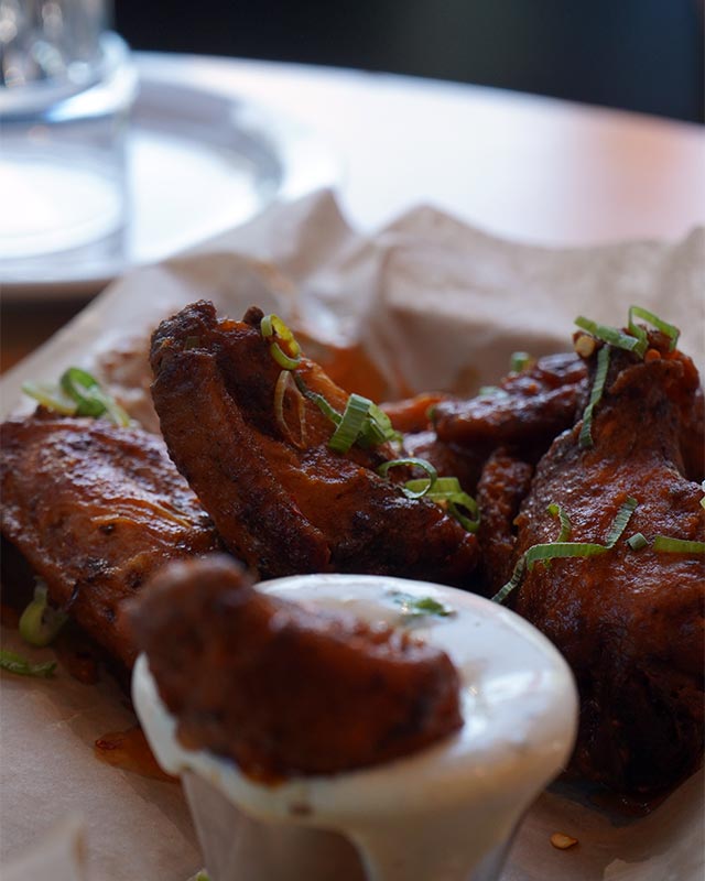 Crispy chicken wings with dipping sauce, a sports bar favorite during happy hour at Red Crown